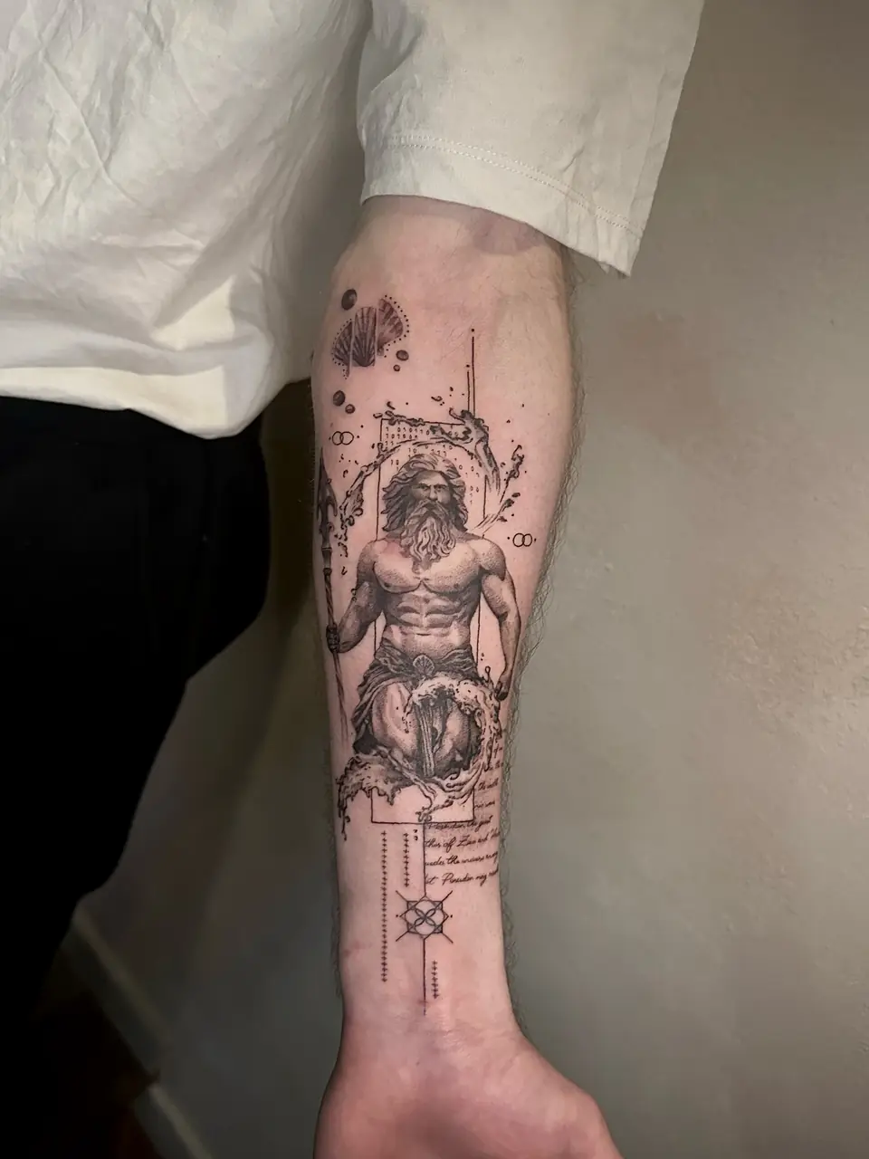 Bearded classical figure surrounded by curling waves, celestial marks and script on the forearm.